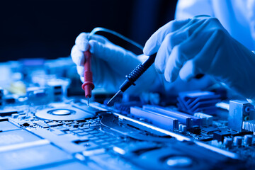 person holding multimeter tool and making  measurement on pcb computer board