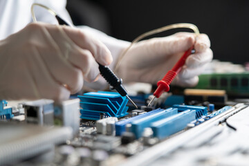 person holding multimeter tool and making  measurement on pcb computer board