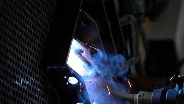 industrial robot is welding automotive part in asia.