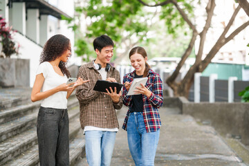 Group of young interracial diverse university students chatting together outside, engaging in a discussion together, college campus, enjoying campus recreation. Happy friends