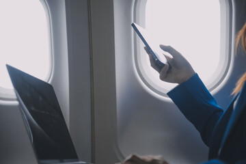 Using mobile and laptop, Thoughtful asian people female person onboard, airplane window, perfectly...