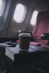 Attractive asian female passenger of airplane sitting in comfortable seat listening music in earphones while working at modern laptop computer with mock up area using wireless connection on board.