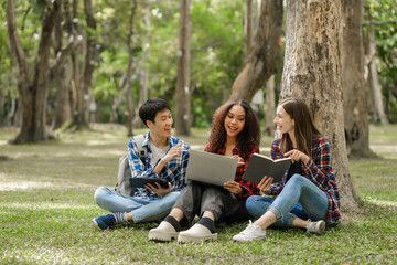 Group of young interracial diverse university students chatting together outside, engaging in a discussion together, college campus, enjoying campus recreation. Happy friends