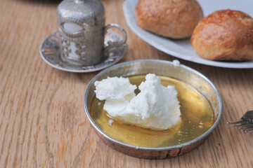 butter cream and honey in a bowl on table .