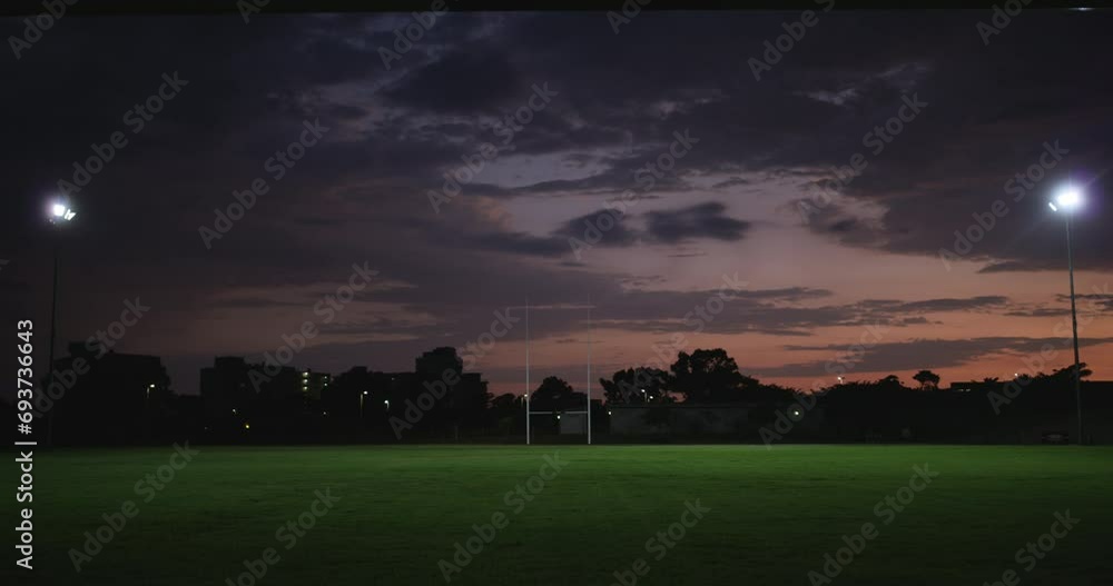 Wall mural Rugby field, night and grass for sports ground with lights and stadium for fitness location in city. Place, pitch and exercise with training club with professional and athlete to train and develop