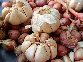 close up view of pile of shallots and garlic with selective focus