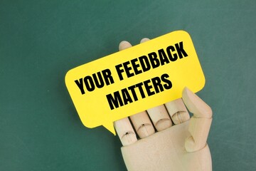 wooden hand holding paper chat box with word Your feedback matters. the concept of reviews or...