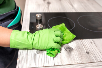 Female janitor with cleaning supplies in kitchen