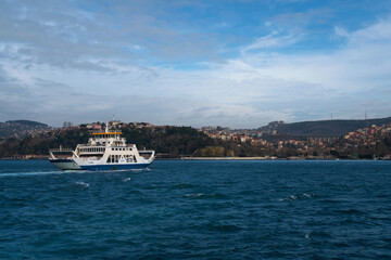Fototapeta premium View of a city passenger ferry in the waters of the Bosphorus Strait against the background of the Asian part of Istanbul and the Beykoz district on a sunny day, Istanbul, Turkey