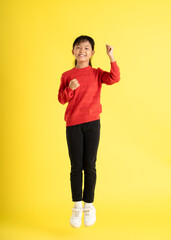 Fototapeta na wymiar full body Image of Asian girl wearing a sweater posing on a yellow background
