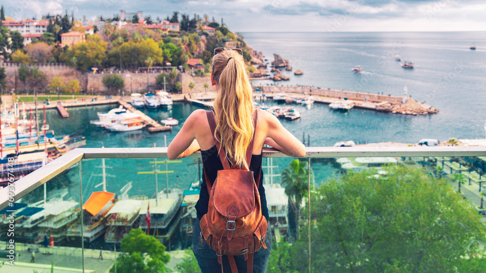 Wall mural woman tourist looking at panoramic view of harbor in the old city of antalya, turkey