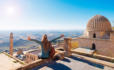 Traveler woman in Turkey,  female tourist sitting on rooftop enjoying panoramic view of Mardin city