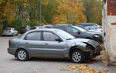 A gray wrecked car is parked near the wall, Podvoysky Street, Saint Petersburg, Russia, October 22,...