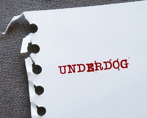 Torn paper with red text written UNDERDOG -  predicted loser in a struggle or contest - people with...