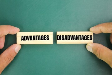 hand holding a stick with the words Advantages and Disadvantages. the concept of advantage or...