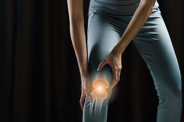 Woman holds her hands to the knee, pain in the knee highlighted in red, medicine, massage concept.