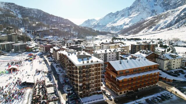 Panoramic aerial drone scenic view at ski slopes, mountain skiing and popular resort town situated on border Switzerland and Italy. Winter landscape in Alps in Aosta Valley, Breuil Cervinia. 4K video.