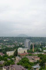  view of the city from the hill. top view of the roofs of houses and the road with cars.