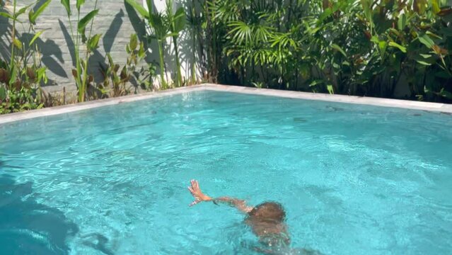 Child boy is drowning in swimming pool