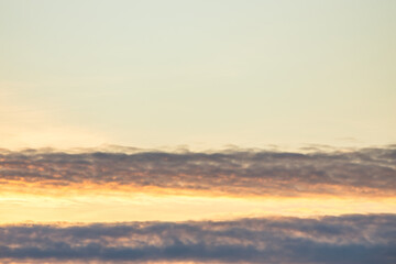 A beautiful sky tinted by the sun leaving vibrant shades of gold, pink, blue and multicolored. Clouds in the twilight evening and morning sky. Image of a cloudy sky in the evening and during the day