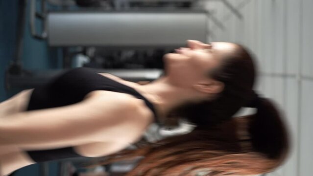 Bodybuilding exercise and sport workout training concept. Strong young fit woman jumping in fitness gym. Woman in sportswear strength muscular in body.