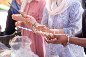 Multi ethnic peoples are in picnic and helping each other while preparing kebab and barbecue