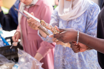 Multi ethnic peoples are in picnic and helping each other while preparing kebab and barbecue