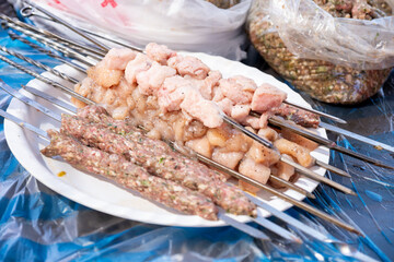 plate of meat and chicken pieces ready to be grilled