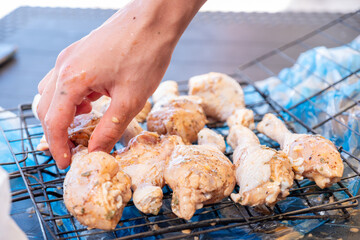 Raw pieces of chicken ready to be grilled on charcoal during holiday