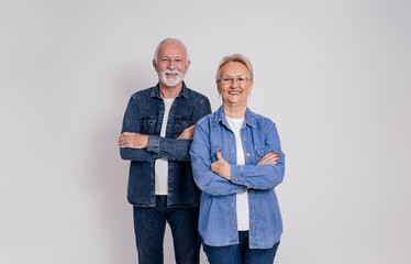 Portrait of happy confident senior husband and wife with arms crossed standing on white background