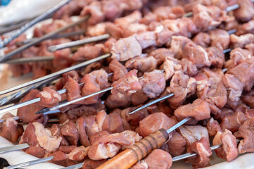 The raw meat pieces are ready to be grilled over the fire and threaded onto metal skewers