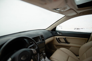 A Frozen Car Windshield Covered with Snowflakes in a Winter Storm. Sitting in the car under the snow during snowfall.