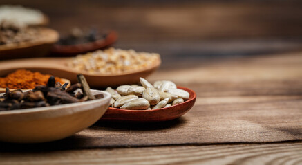 Many different spices in wooden spoons on a wooden background, background with spices, spices in...