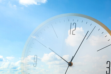 Time concept. Double exposure of blue sky with fluffy clouds and clock