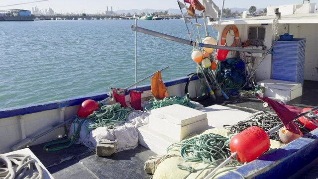 Fishing boats and ships in the port of Castellon in winter. Port cranes on the horizon. Red floats for nets. Port of El Grao. Spain