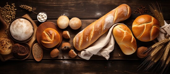 Sweet bread and rolls arranged on a table with baking tools, viewed from above, empty space available.