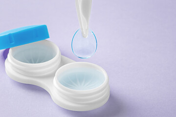 Contact lenses with tweezer and container on pastel purple background