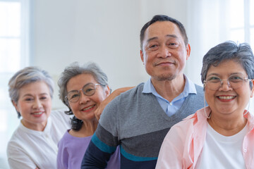 group of asian senior people standing with smart confidence. older people are listening and enjoy meeting focus group at living room. Joyful carefree retired senior friends enjoying relaxation.