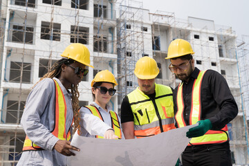 Foreman builder male and female at construction site. Group of foreman construction working at construction site, wearing safety uniform, helmet and holding blueprint structure - Powered by Adobe
