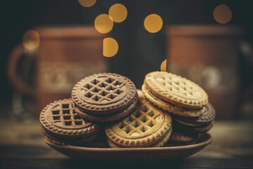 Chocolate and vanilla round cookies on a wooden table with a cup of coffee, round cookies on the...