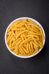 Raw whole grain wheat pasta with salt and spices in a ceramic plate