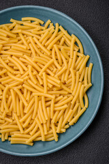 Raw whole grain wheat pasta with salt and spices in a ceramic plate