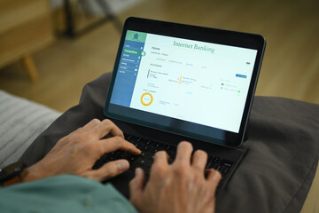 Closeup senior man managing his bank account and transferring money online on digital tablet
