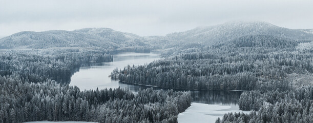 Taiga forest landscape with a lake and hills in winter - 693864676