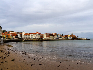 Fototapeta na wymiar Old dock area in the town of Luanco from La Ribera beach. Asturias, Spain.