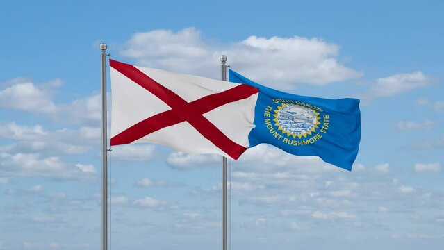 South Dakota and Alabama US state flags waving together on cloudy sky, endless seamless loop