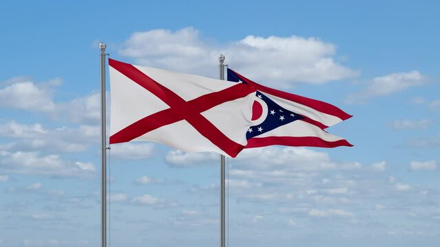 Ohio and Alabama US state flags waving together on cloudy sky, endless seamless loop
