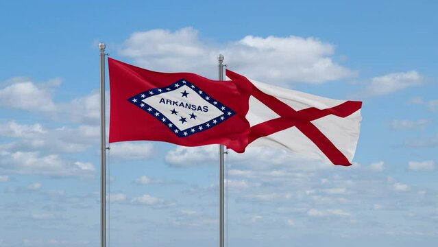 Alabama and Arkansas US state flags waving together on cloudy sky, endless seamless loop