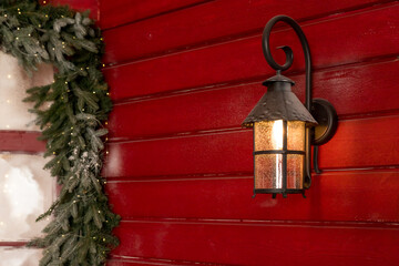 Old Christmas lantern on wooden wall background.Street lantern decorated for Christmas, burning iron black lantern