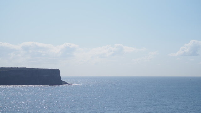 Ocean with blue sky and coast as background